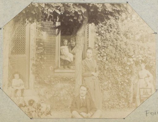 Group portrait of a (probably) French family in a garden by a house