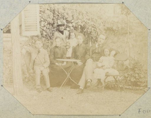Group portrait of a (probably) French family in a garden by a house