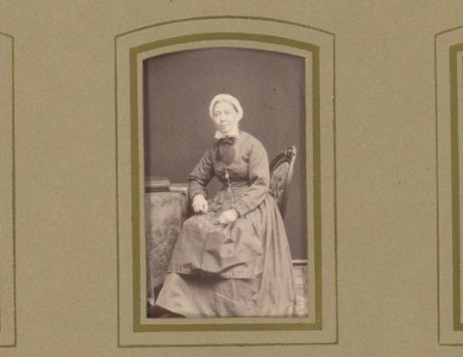 Portrait of a woman, seated at a table with a book