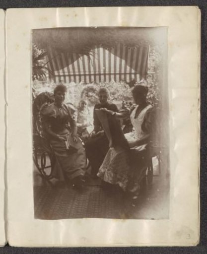 Three women and a girl sitting under a shelter