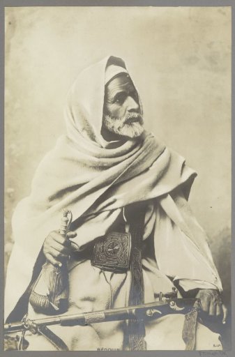 Portrait of a Bedouin with rifle on lap