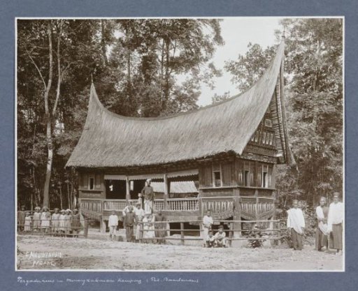 Men, women and children posing in front of a meeting house in Minangkabau in Sumatra