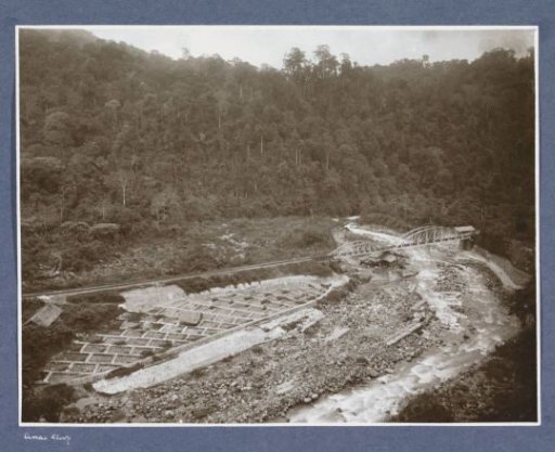 View of a riverbed with railway, railway bridge and fields in the Anai Gorge on Sumatra