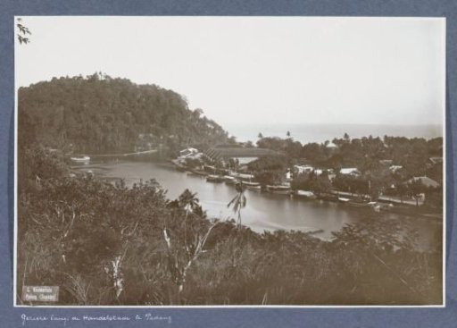 View of the Handelskade in Padang with ships, warehouses and houses