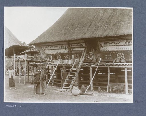 Batak women and children posing in front of a house on Sumatra