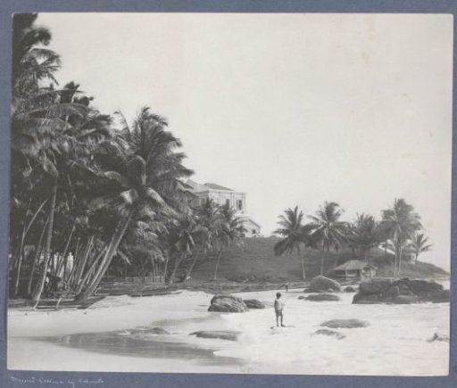Beach near Mount Lavinia (Colombo) with palms, villa and child in the surf