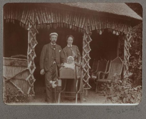 Man and woman with a child in a pram standing in front of a shelter
