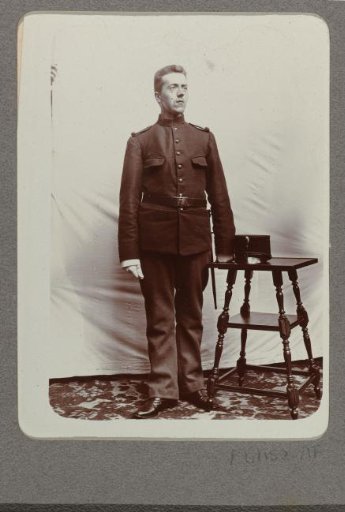 Portrait of a man standing next to a small table