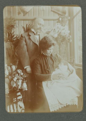 Portrait of a man and a woman with a baby on her lap