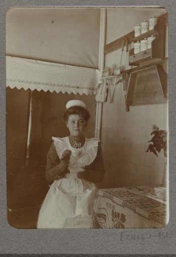 Portrait of a maid, drinking coffee in the kitchen