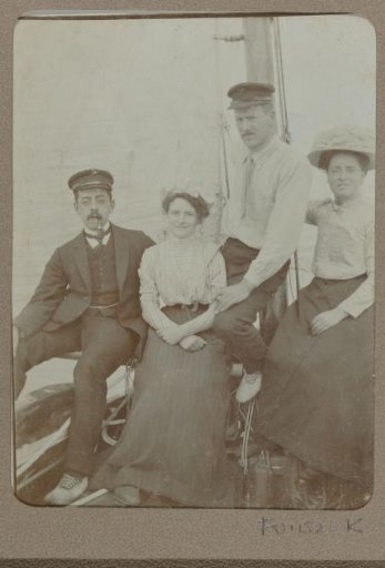 Group portrait of two men and two women on a boat before the mast