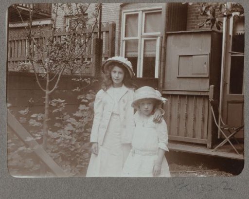 Two girls standing in front of a house