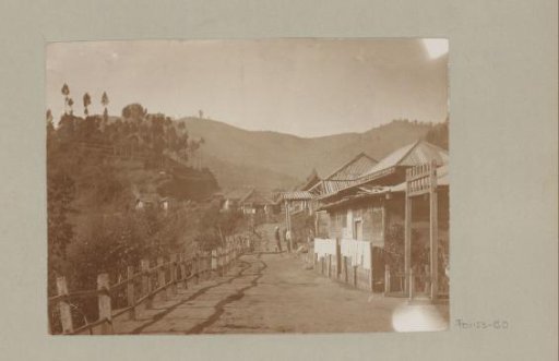 Path along houses with mountains in the background