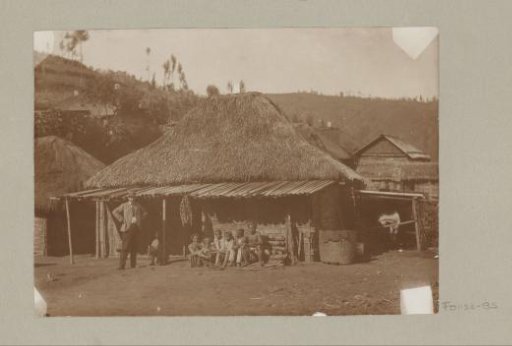 European man and Indonesian family in front of a house