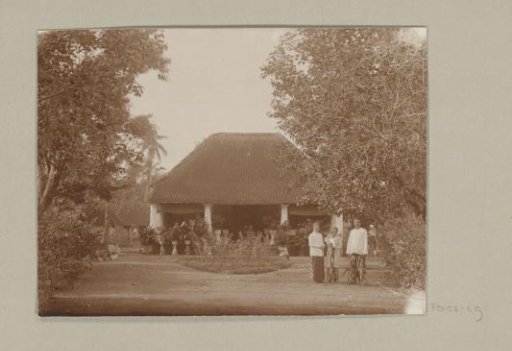 Man and woman with child in front of a greenhouse