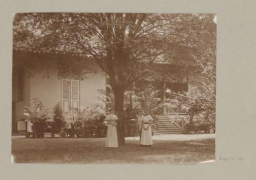 Two young women in front of a house