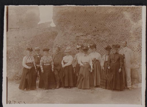 Group portrait of men and women before a ruin (possibly) in Italy