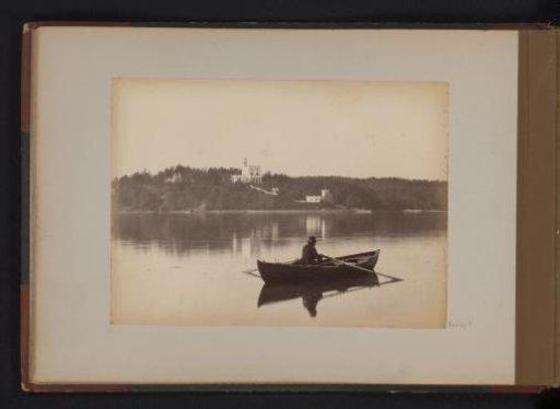 Man in a rowing boat on a lake, presumably in Scandinavia
