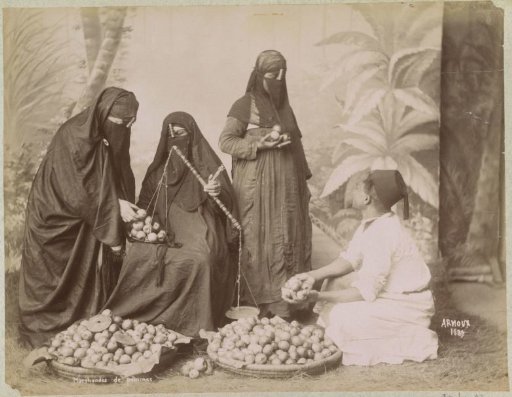 Portret van een appelverkoper met gesluierde klanten in Egypte