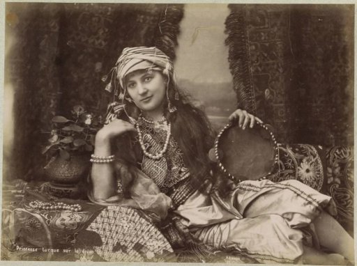 Portrait of a Turkish woman with a tambourine in her hand, reclining on a divan