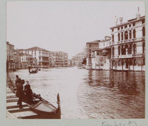 Canal Grande with palaces in Venice, with a woman in a gondola in the foreground