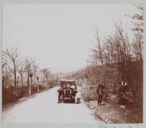 Car, man and woman by the roadside, presumably in Northern Italy