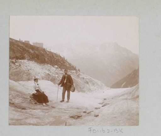 Man and woman on a mountain path through the Alps