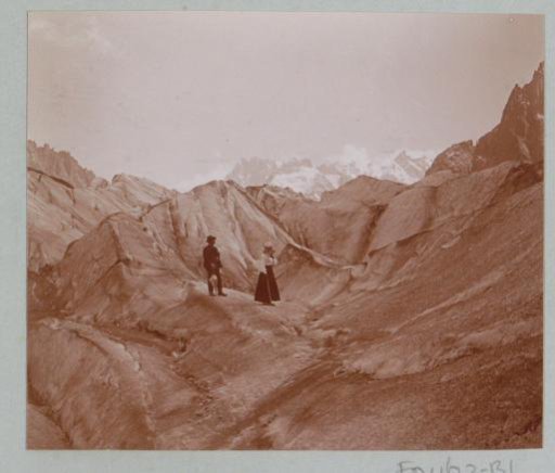 Man and woman on a mountain path through the Alps