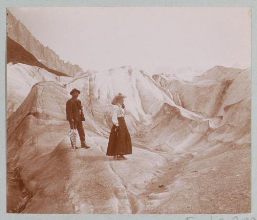 Man and woman on a mountain path through the Alps