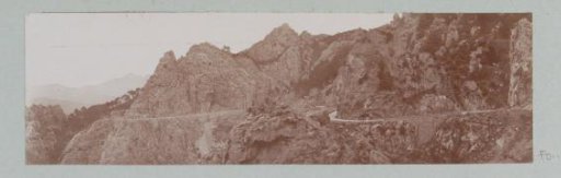 Mountain landscape with a road along bare rocks, probably in Corsica