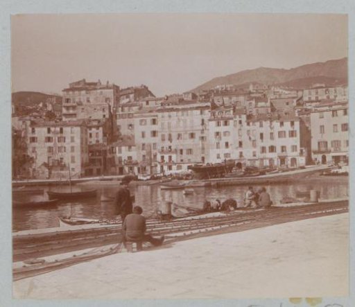 View of the harbor of Bastia with net-mending fishermen in the foreground
