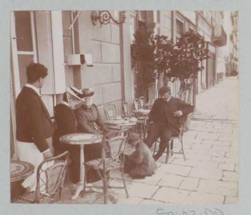 Company on the terrace of Brasserie Gasparini on Corsica, with a waiter and presumably a shoeshiner