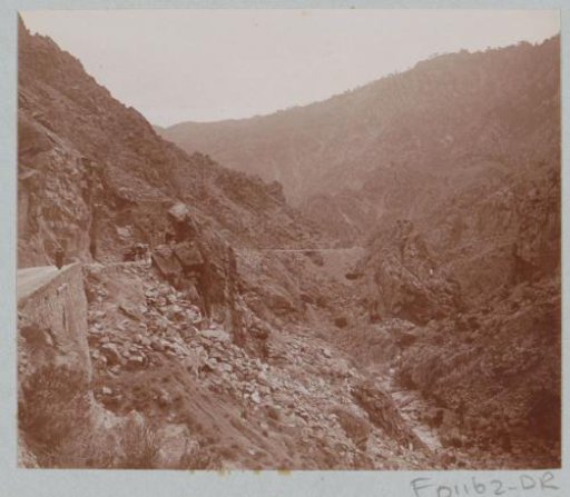 View of a gorge in Corsica with a car with passengers on the left
