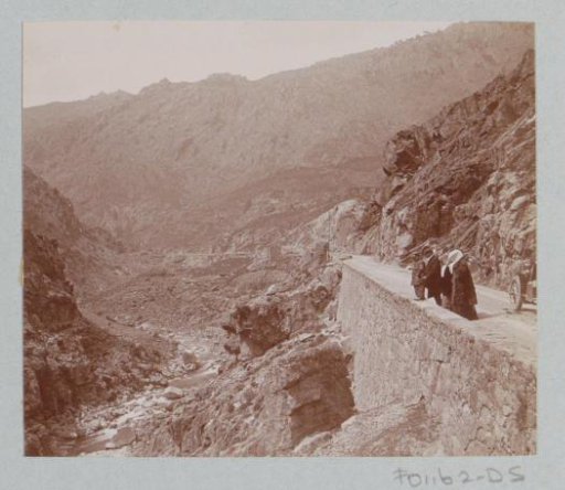 View of a gorge in Corsica with a car with passengers on the right