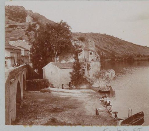 Village on a river in France with women washing in the foreground