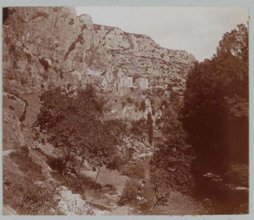 Mountain village against the rocks in France with a riverbank in the foreground
