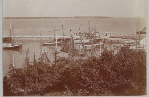 View of a harbor in France with sailing boats and a pier