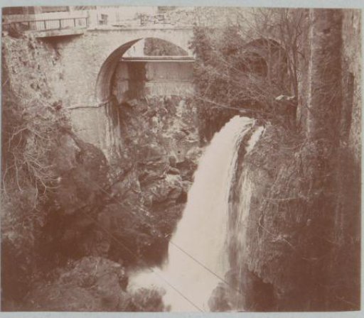 Waterfall near a bridge, probably in southern France