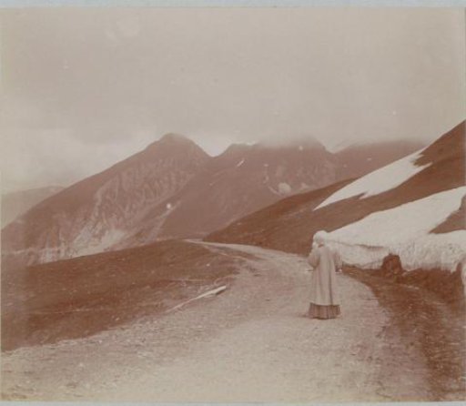 Woman in a long cloak on a snowy mountain pass, probably in France