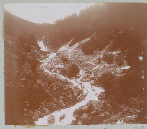 Mountain stream with barns along it, probably in the Pyrenees