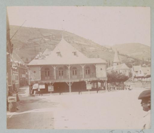 Village view with a house on stilts with a veranda in the center, probably in the Pyrenees