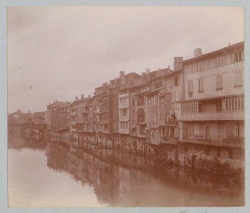 View of a row of houses by water, probably in France