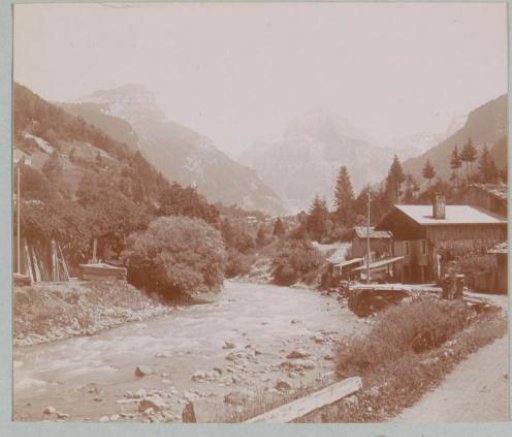 Mountain landscape with a stream and houses in the Alps