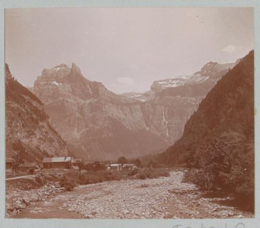 Mountain landscape with a stream bed and houses in the Alps
