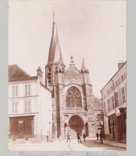 Street and the church Notre-Dame with a twisted spire in Puiseaux