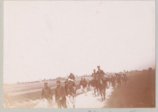 Soldiers on horseback and on foot on a country road in France