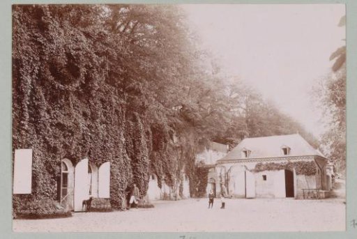 Men and child on a courtyard (designated 'La Charpenterie'), presumably at a country house or castle in France