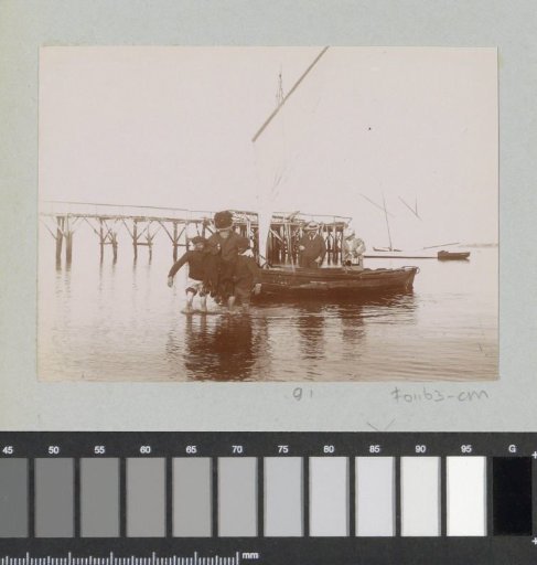 Woman being carried from a sailing boat to the shore, probably off the coast of Le Moulleau near Arcachon