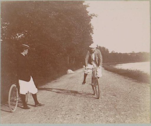 Two men on bicycles along a river at Pontoise