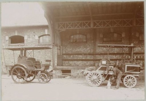 Man working with two automobiles connected by a rope in France